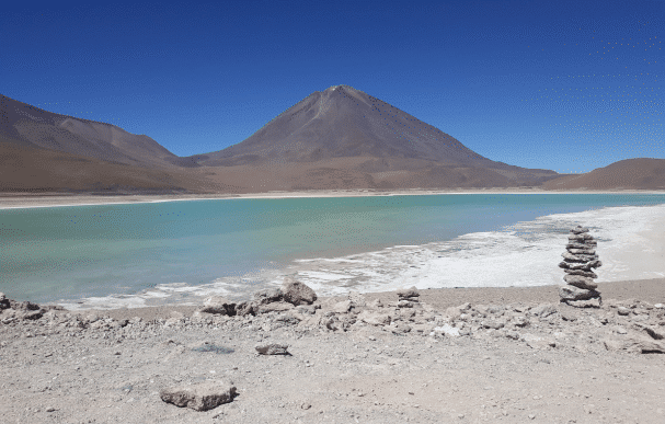 La splendide Laguna Verde, située en Bolivie, offre une vue panoramique sur ses eaux turquoise et les majestueuses montagnes environnantes. Découvrez la beauté naturelle de ce lieu unique au cœur de la cordillère des Andes. Photographe : Espaces Andins
